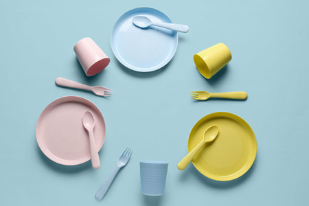 Frame made of different eating utensils for baby on blue backgroundの写真素材
