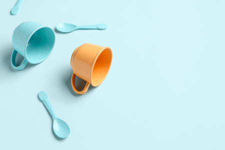 Different colorful cups with spoons on blue background. Children's Day celebration