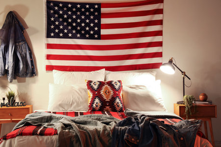 Interior of bedroom with USA flag and glowing lamp in the eveningの写真素材