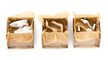 Cardboard boxes with different shoes on white background