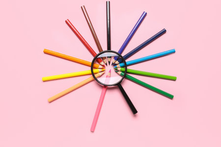 Magnifier with frame made of colorful pencils on pink backgroundの写真素材