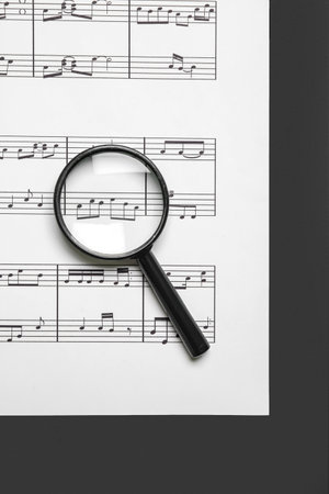 Magnifier with music sheet on black and white backgroundの写真素材