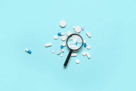Magnifier with pills on blue backgroundの写真素材