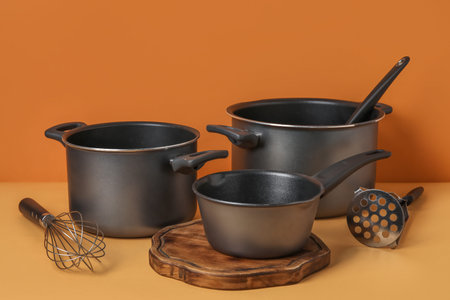 Set of kitchen pots and kitchen utensils on color backgroundの写真素材