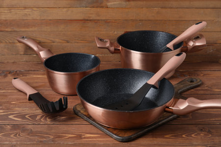 Set of copper cooking pots and kitchen utensils on wooden backgroundの写真素材