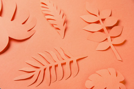 Beautiful origami leaves on orange background, closeupの写真素材