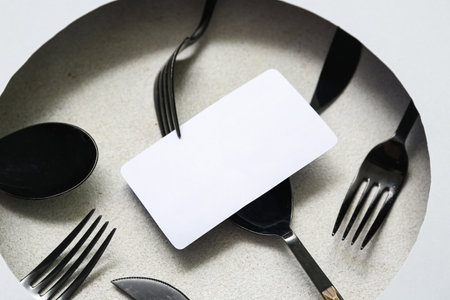Composition with blank card and cutlery on light background, closeupの写真素材