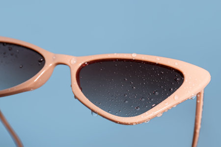 Stylish beige sunglasses on blue background, closeupの写真素材