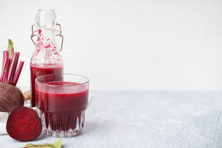 Bottle and glass of fresh beetroot juice on light backgroundの写真素材