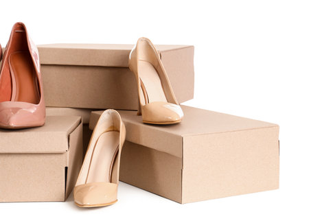 Cardboard boxes with beige high-heeled shoes on white backgroundの写真素材