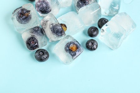 Fresh blueberry frozen in ice on blue backgroundの写真素材
