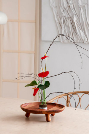 Beautiful ikebana on dining table in roomの写真素材