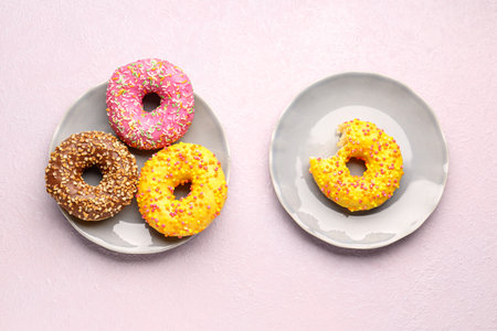 Plates with sweet donuts on light backgroundの写真素材