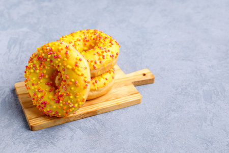 Board with sweet donuts on blue grunge backgroundの写真素材