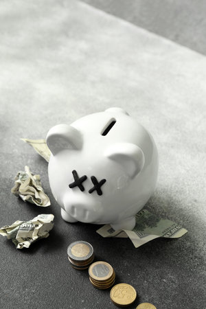 Piggy bank with closed eyes and money on grunge background. concept of bankruptcyの写真素材