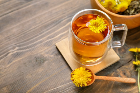 Bowl and glass cup of healthy dandelion tea on wooden backgroundの写真素材