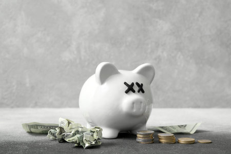 Piggy bank with closed eyes and money on grunge background. concept of bankruptcyの写真素材