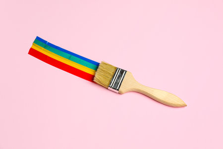 Paint brush with adhesive tapes on pink backgroundの写真素材