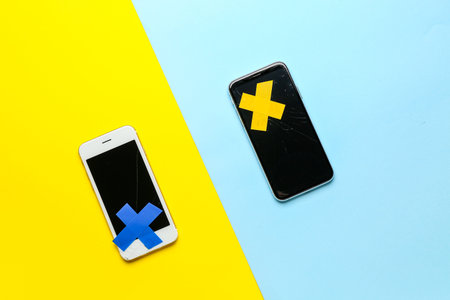Mobile phones with adhesive tapes on color background