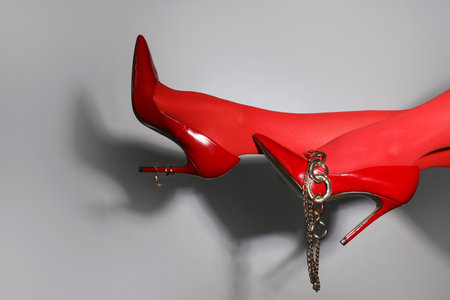 Female legs in red tights and high heels with accessories on gray backgroundの写真素材