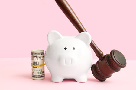 Piggy bank with judge gavel and money on pink background. bankruptcy conceptの写真素材