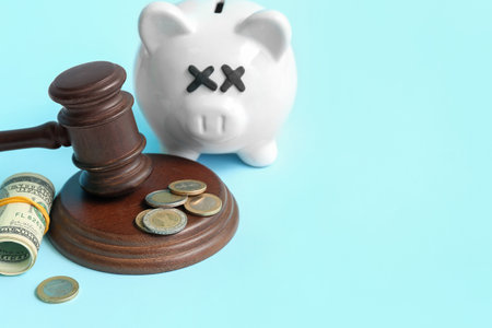 Piggy bank with judge gavel and money on blue background. bankruptcy conceptの写真素材