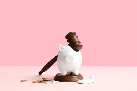 Broken piggy bank with judge gavel and money on pink background. bankruptcy conceptの写真素材