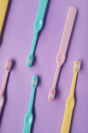 Many plastic toothbrushes on purple backgroundの写真素材