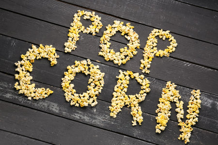 Text POP CORN on dark wooden backgroundの写真素材