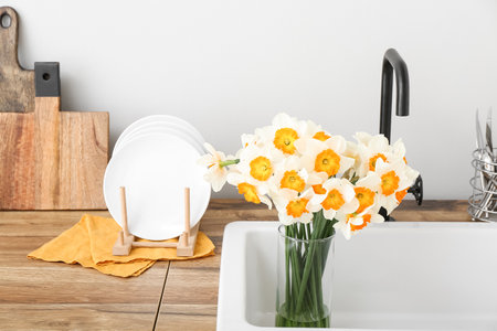 Vase with blooming narcissus flowers in sink, closeupの写真素材