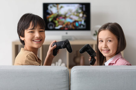 Little children playing video games at home