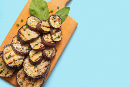 Board with delicious grilled eggplants on light blue background, top viewの写真素材