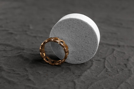 Decorative podium with beautiful ring on black background