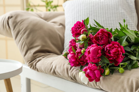 Bouquet of peonies lying on couch in living roomの写真素材