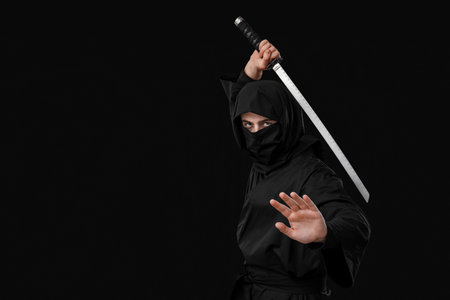 Male ninja with sword on black backgroundの写真素材