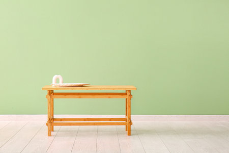 Wooden table with porcelain dish near green wallの写真素材