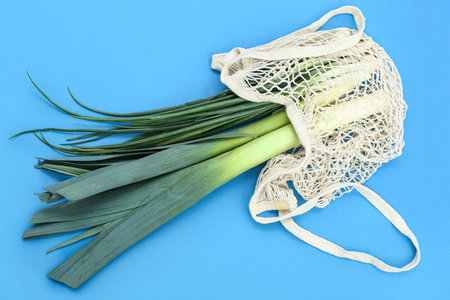 String bag with different kinds of onions on blue backgroundの写真素材