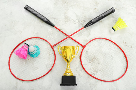 Gold cup with badminton rackets and shuttlecocks on grunge backgroundの写真素材