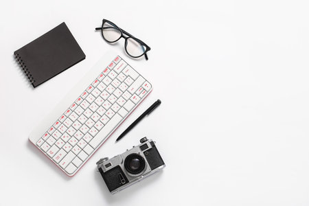 Composition with glasses, photo camera and keyboard on white backgroundの写真素材