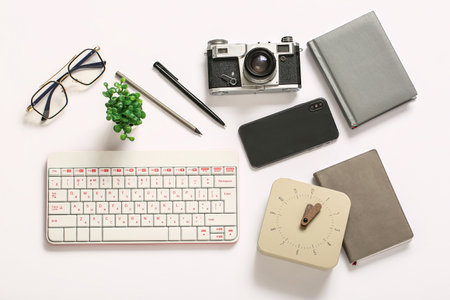 Composition with glasses, photo camera, keyboard and mobile phone on white backgroundの写真素材