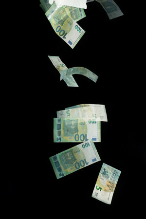 Stroboscopic photo of falling euro banknotes on dark backgroundの写真素材
