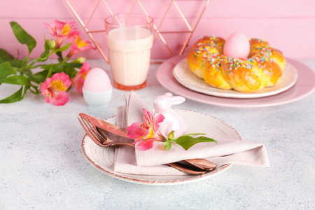 Beautiful table setting with tasty Italian Easter bread, glass of milk and alstroemeria flowers on...