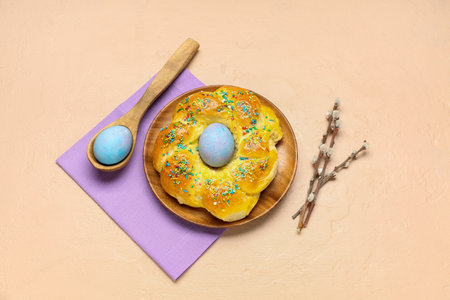 Plate with tasty Italian Easter bread, eggs and willow branches on color backgroundの写真素材