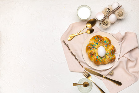 Composition with tasty Italian Easter bread, eggs and glass of milk on light background