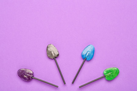 Composition with sweet lollipops on purple background