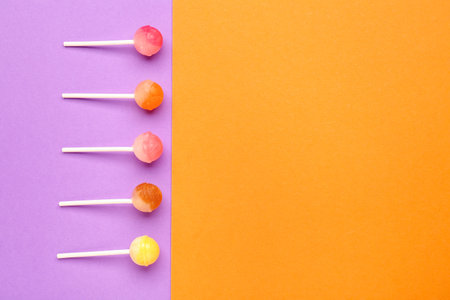 Sweet lollipops on purple and orange backgroundの写真素材