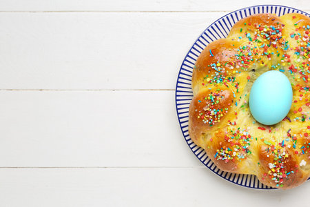Plate with tasty Italian Easter bread on white wooden backgroundの写真素材