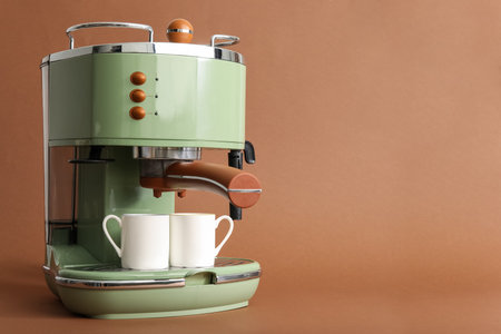 Modern coffee machine with cups on brown backgroundの写真素材