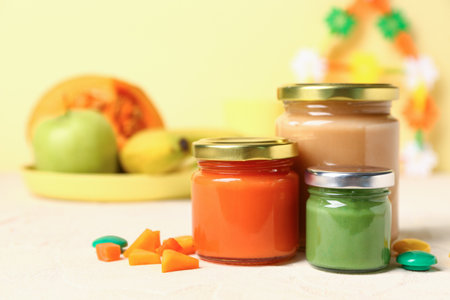 Jars of healthy baby puree on color backgroundの写真素材