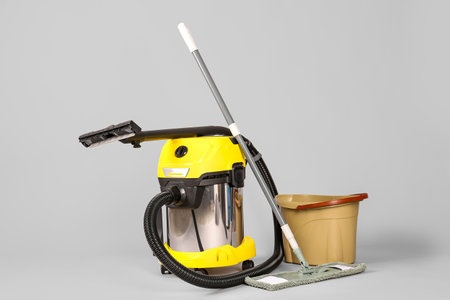 Vacuum cleaner with mop and bucket on gray backgroundの写真素材